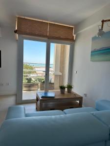 una sala de estar con 2 sofás azules y una ventana grande en La Savina Ses Platgetes, en La Savina 38 fotos más