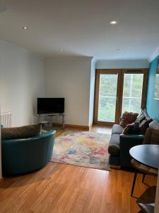 a living room with a couch and a television at Apt 7 Cathedral & River view in Norwich