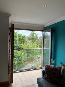 a living room with a large window and a couch at Apt 7 Cathedral & River view in Norwich +3 photos