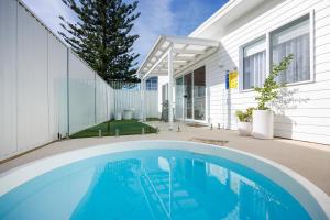 a swimming pool in front of a house at Olas Villa 6 - Plunge Pool & Walk to Beach in Anna Bay