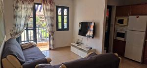 Una sala de estar con un sofá azul y una cocina. en Vivienda vacacional A38473 bonita, agradable y tranquila en Tenerife, en Costa del Silencio