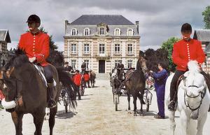 a group of people riding horses in front of a building at Le Lodge Serene Self Catering in Bures-les-Monts