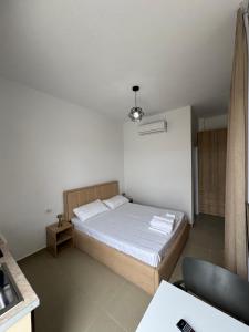 una piccola camera da letto con un letto e una scrivania di Vila S&S a Vlorë