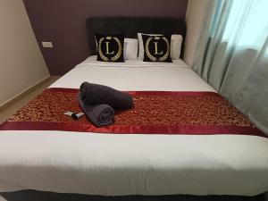een bed met een zwarte hoed en een handdoek erop bij L Ferringhi Hotel in Batu Ferringhi