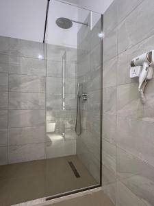 una doccia con una porta in vetro in un bagno di Vila S&S a Vlorë Altre 30 foto