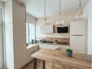 a kitchen with white cabinets and a wooden table at T2 centre ville de Perros Guirec in Perros-Guirec +5 photos