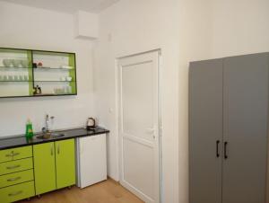 a kitchen with green and white cabinets and a door at Guesthouse David i Spoma in Međugorje