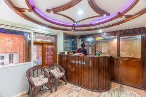 a person sitting at a bar in a restaurant at OYO 830 Hotel Amrit Kunja in Kathmandu