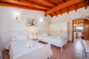 two beds in a room with white walls and wooden ceilings at Son Fransi Alaro in Alaró +30 photos