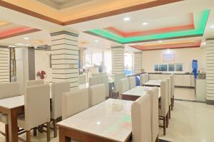 a dining room with tables and white chairs at OYO 828 Hotel White Dreams Palace in Kathmandu