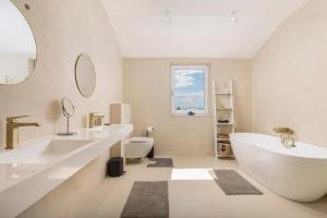 a bathroom with two sinks and a tub and a toilet at Villa Carla house with hot tub and beautiful garden in Ičići +73 photos