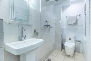 a white bathroom with a sink and a toilet at OYO 830 Hotel Amrit Kunja in Kathmandu