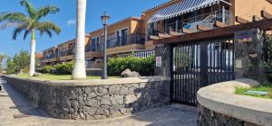 Una puerta frente a un edificio con una palmera. en Vivienda vacacional A38473 bonita, agradable y tranquila en Tenerife, en Costa del Silencio