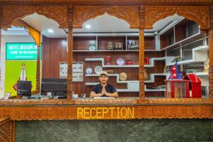 a man sitting at a bar in a restaurant at OYO 831 Hotel Mission Inn Pvt Ltd in Kathmandu