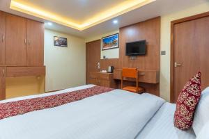 a hotel room with a bed and a desk at OYO 831 Hotel Mission Inn Pvt Ltd in Kathmandu