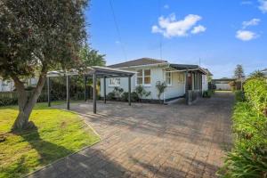 a house with a brick driveway in front of a house at Rotorua Forest Getaway in Rotorua