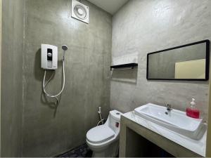 a bathroom with a white toilet and a sink at ไวท์เฮาส์โฮมสเตย์24ชั่วโมง in Ban Sam Sen
