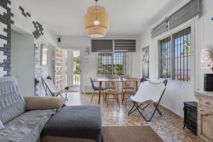 a living room with a couch and a table and chairs at Chalet Novo Sancti Petri Surf in Chiclana de la Frontera