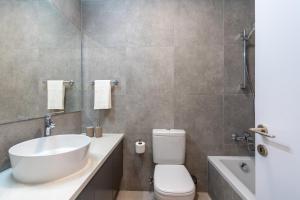 Un baño con lavabo, inodoro y bañera. en Elegant villa with pool view, en Klorakas