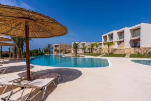 una piscina con sombrilla y sillas y un edificio en Elegant villa with pool view, en Klorakas
