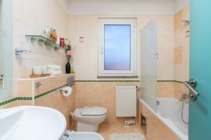 a bathroom with a toilet and a tub and a sink at Apartman Kvarner in Rijeka +16 photos