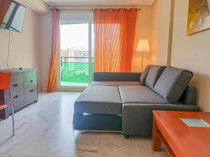 a living room with a couch and a large window at Apartment VilaPark with pool, free parking, terrace, beach in Benidorm