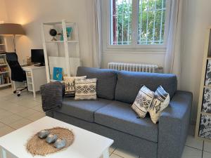 a living room with a blue couch and a table at Sweet Home - 55m2 appartment, garden, swimming pool, parking in Toulouse