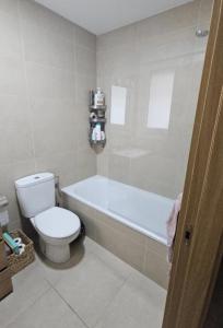 a bathroom with a toilet and a bath tub at Habitación doble con baño in Basauri