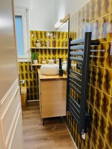 布科·莱斯白老城Chambre d'Hôtes du Lac的一间带水槽和黄色瓷砖墙的浴室