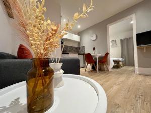 a vase with flowers on a white table in a living room at Le Terracotta proche Centre Ville et Caserne in Chalon-sur-Saône