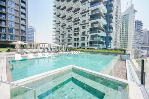 a swimming pool with chairs and a large building at Stylish Retreat in Business Bay in Dubai