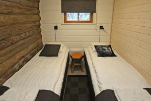 two beds in a small room in a tiny house at Kuukkeli Log Houses Aurora Cabin - Jaspis in Saariselka