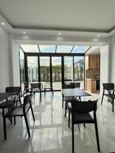 a dining room with tables and chairs and windows at Villa Papa-Berat in Berat +47 photos