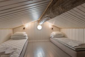 two beds in a room with white walls at Kuukkeli Log Houses Aurora Cabin - Jaspis in Saariselka +21 photos