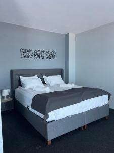 a bedroom with a large bed with white pillows at Family Hotel Sunrise in Lozenets