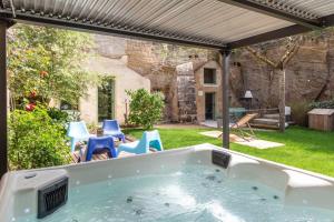 un jacuzzi extérieur dans une cour arrière avec des chaises dans l'établissement La Petite Perrière Gite, à Doué-la-Fontaine
