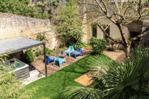 2 chaises bleues assises sur une terrasse dans un jardin dans l'établissement La Petite Perrière Gite, à Doué-la-Fontaine 8 autres photos