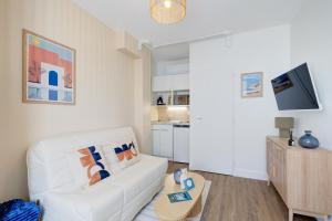 a living room with a white couch and a table at Le City - 800 m Gare - Hyper Centre - WiFi- Climatisé in Tours
