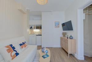 a living room with a white couch and a kitchen at Le City - 800 m Gare - Hyper Centre - WiFi- Climatisé in Tours