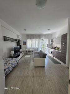 a large living room with a couch and a bedroom at Calliope in Terracina