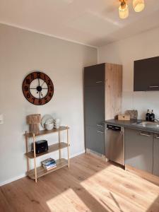 a kitchen with a clock on the wall and a counter at Hygge Homes - Design Apartment Nähe Schloss in Celle