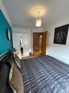 a bedroom with a bed and a blue wall at Apt 5a Central by river 1 Bed Apartment in Norwich