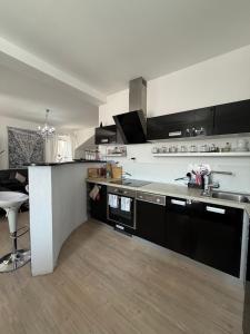 a kitchen with black and white cabinets and a table at Apartmán Residenz in Poprad +28 photos