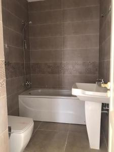 ein Badezimmer mit Badewanne, Toilette und Waschbecken in der Unterkunft Apartment 160 m for rent, CELIA Compound TMG, direct on the green river, New Administration Capital in Madīnat al Amal