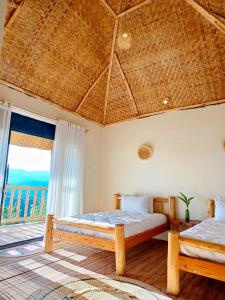 a bedroom with two beds and a large window at Bwindi Neckview Lodge in Buhoma