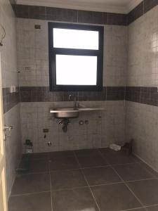ein Badezimmer mit Waschbecken und Fenster in der Unterkunft Apartment 160 m for rent, CELIA Compound TMG, direct on the green river, New Administration Capital in Madīnat al Amal