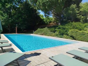 a swimming pool with chairs on a wooden deck at Domaine borgnette fantastique maison in Moulidars