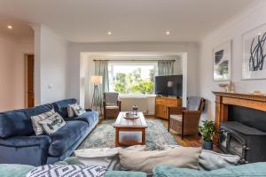 a living room with blue couches and a fireplace at Warblers - West Wittering in Chichester