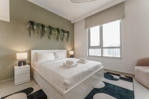 a bedroom with a white bed and a window at Prime Downtown 2BR Retreat in Dubai +12 photos