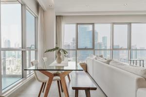 a living room with a glass table and white chairs at Prime Downtown 2BR Retreat in Dubai